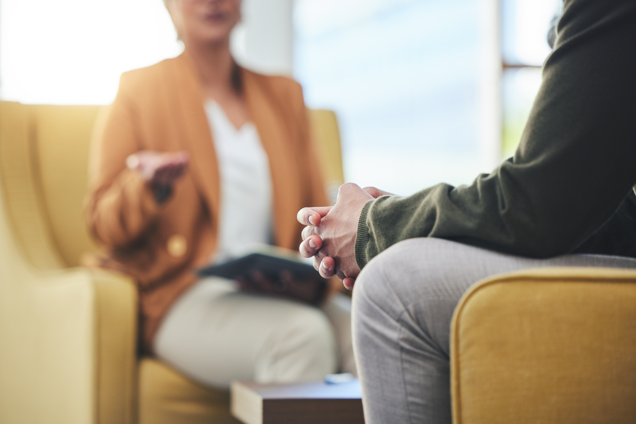 A man and woman sit facing each other and talking.